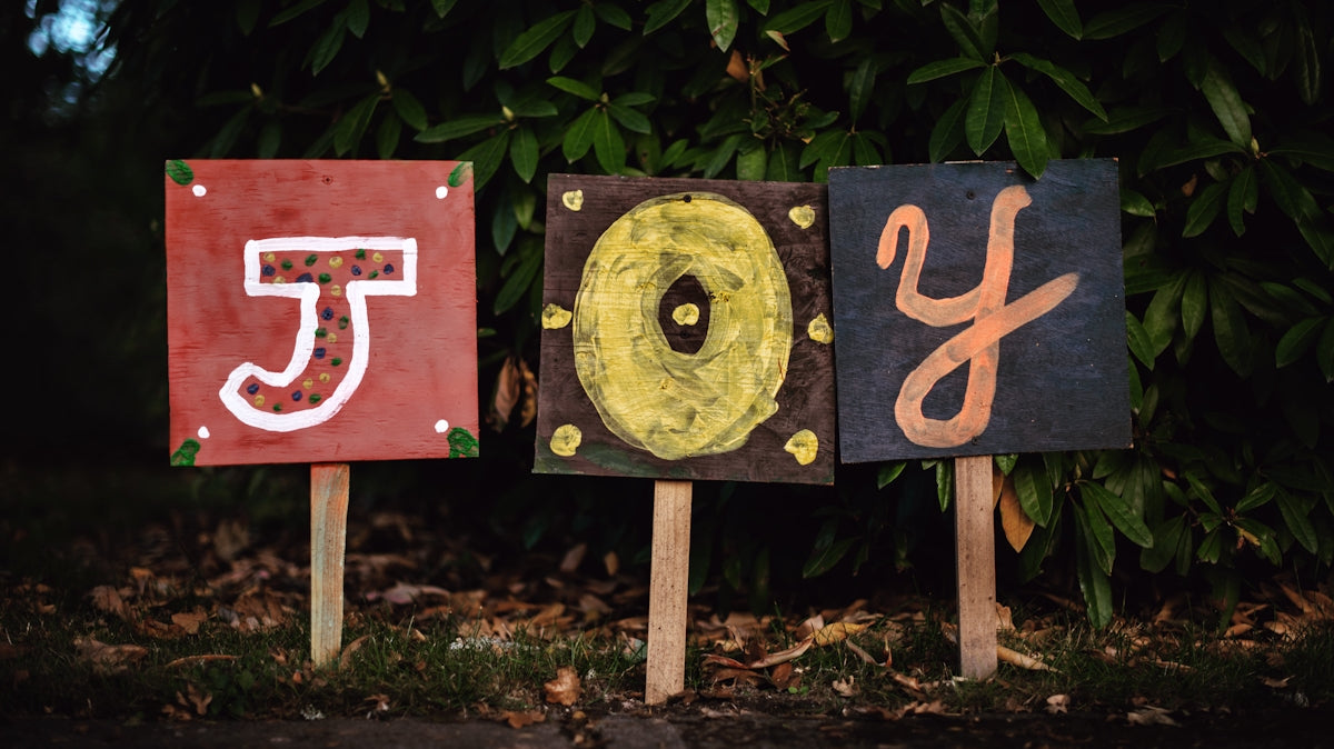 three assorted-color joy signage