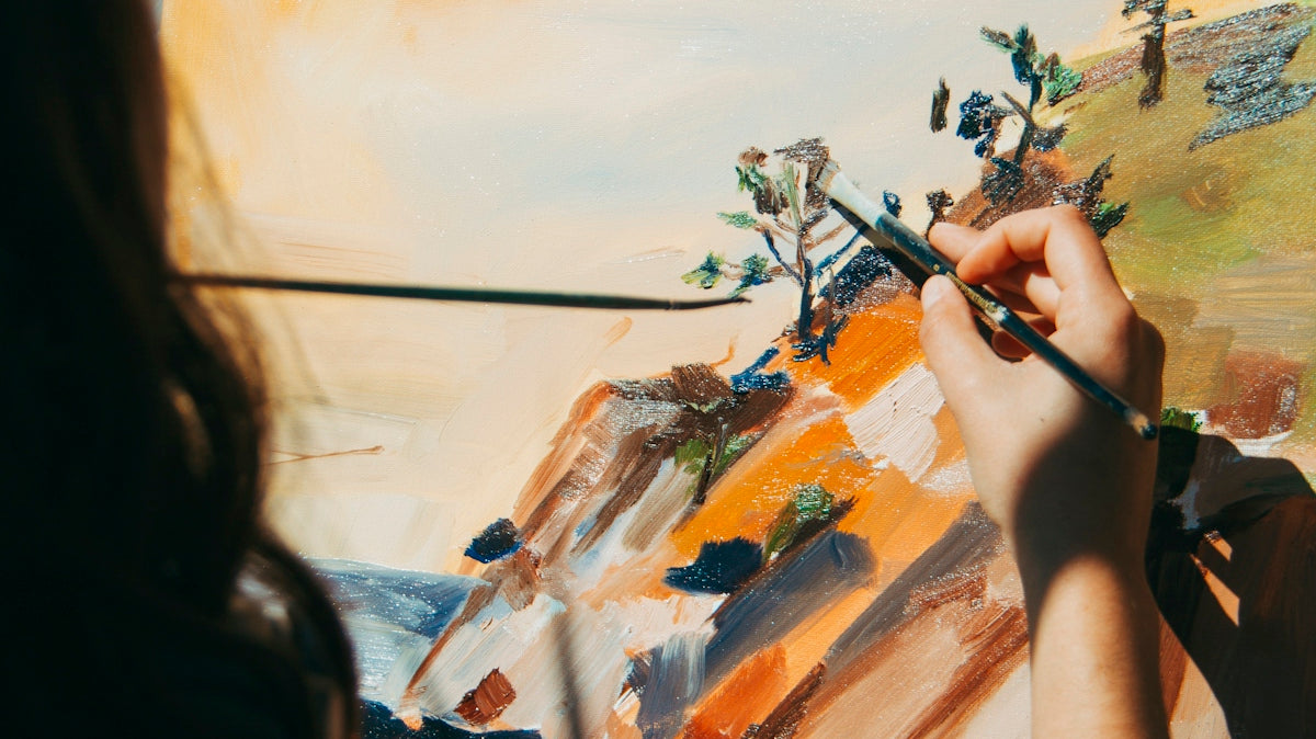 woman painting tree and cliff