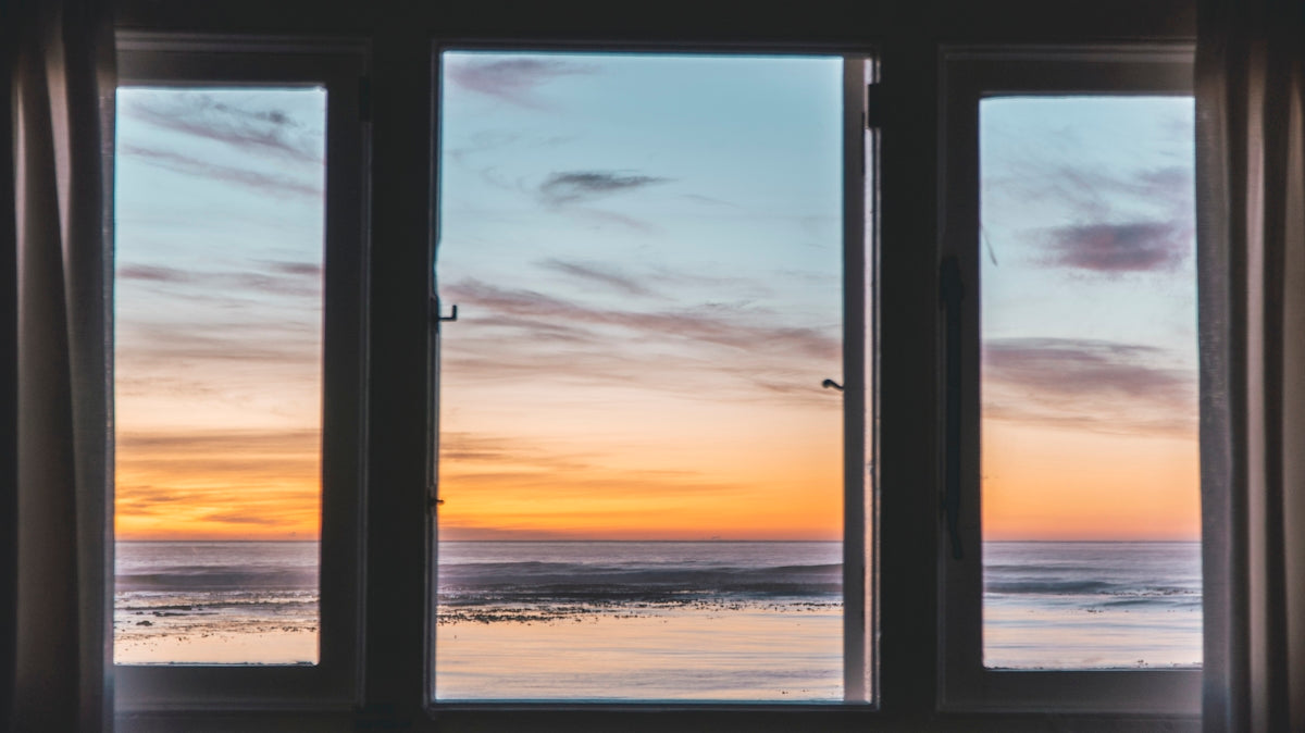 white wooden framed glass window near body of water