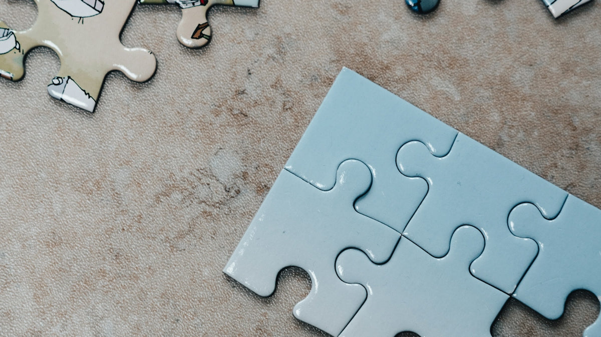 white jigsaw puzzle pieces on brown marble table