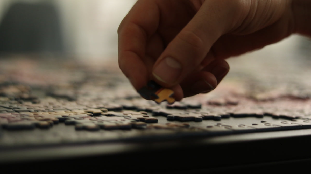 a person placing a piece of a puzzle together