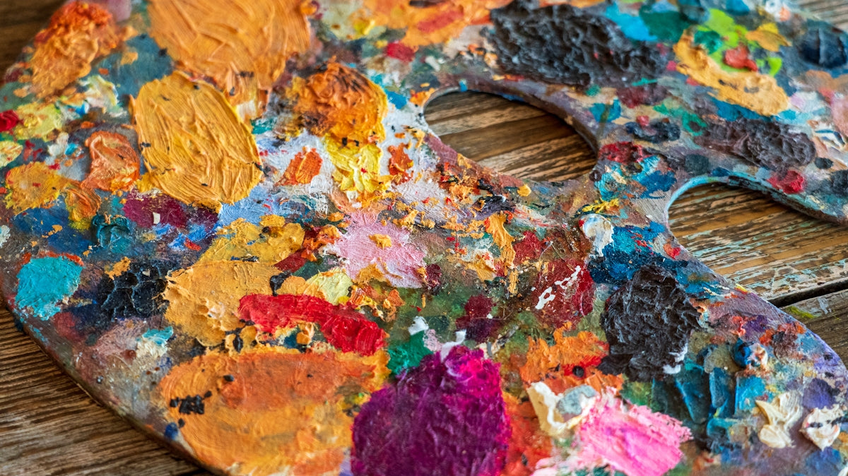 a wooden table topped with a paint palette