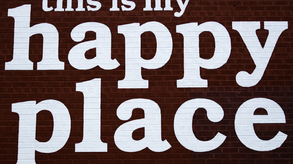 this is my happy place sign painted on a brick wall