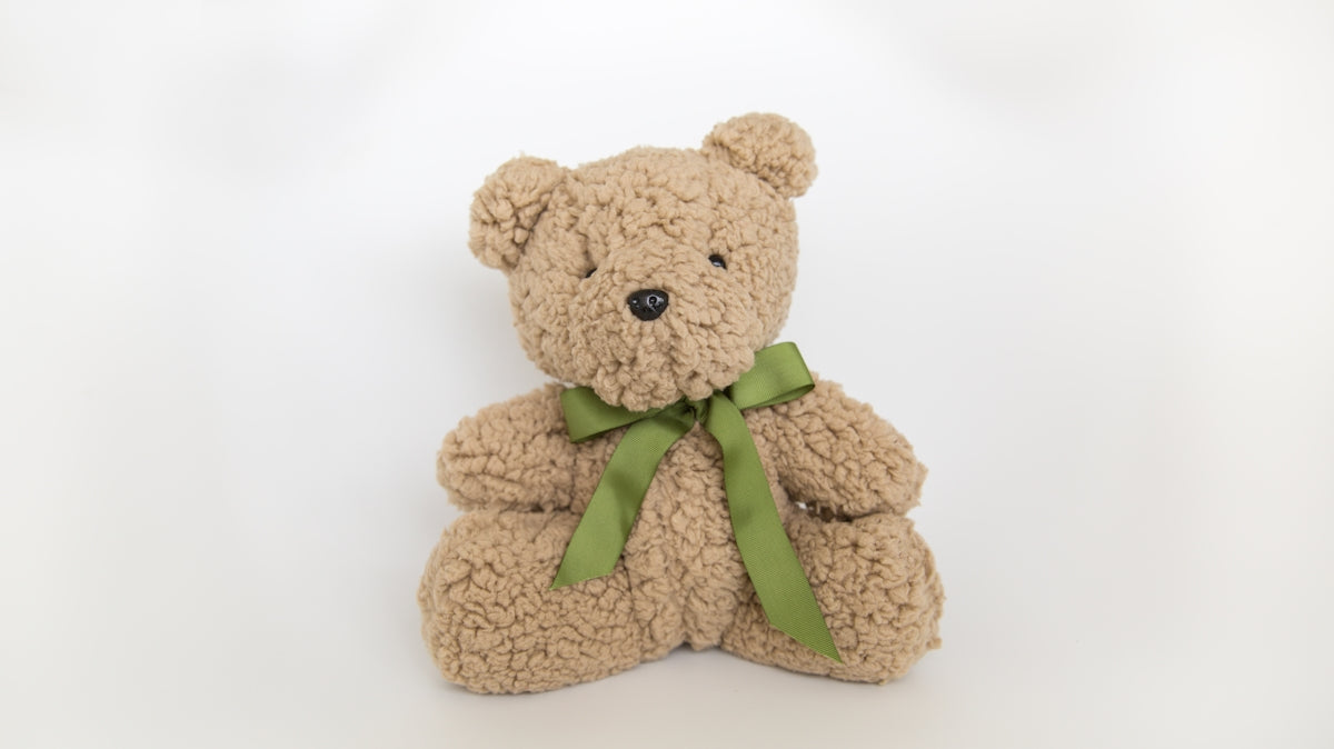 a stuffed bear with a green bow