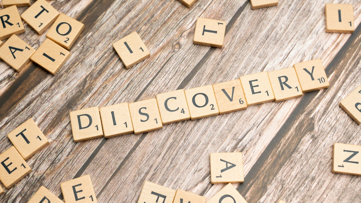 scrabble tiles spelling discovery on a wooden surface
