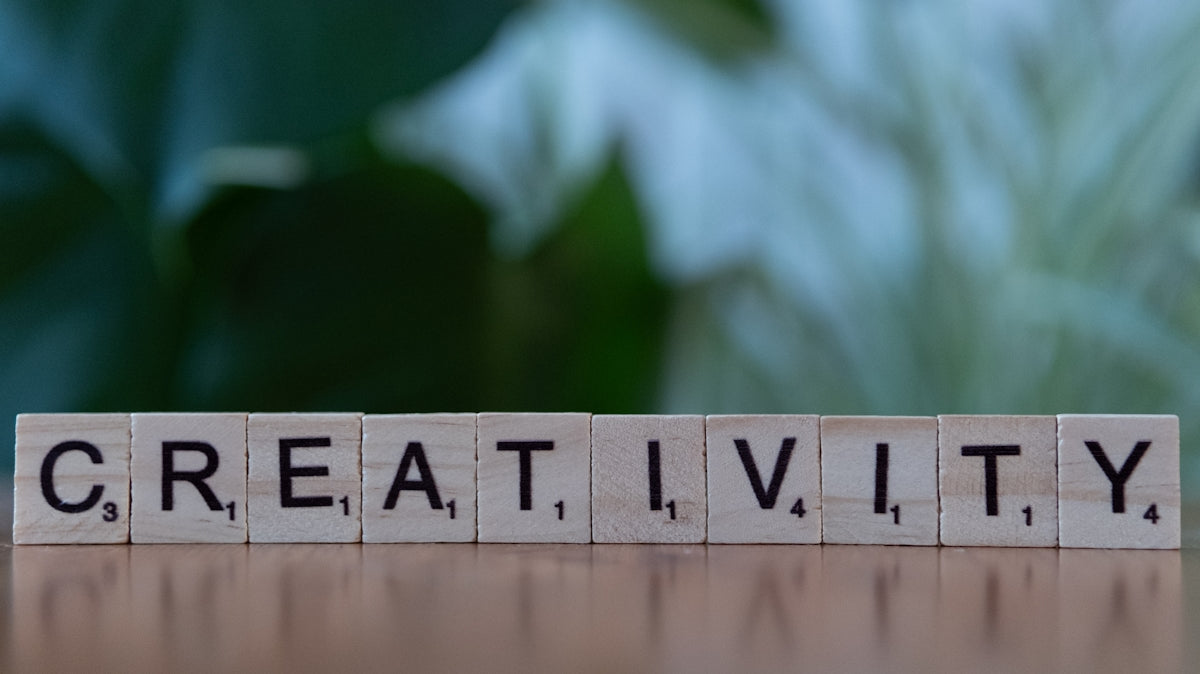 A wooden block that says creativity on it