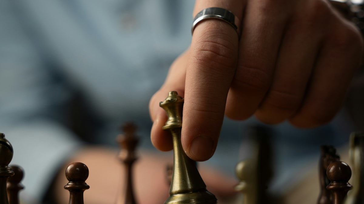 Person moving a chess piece on a board