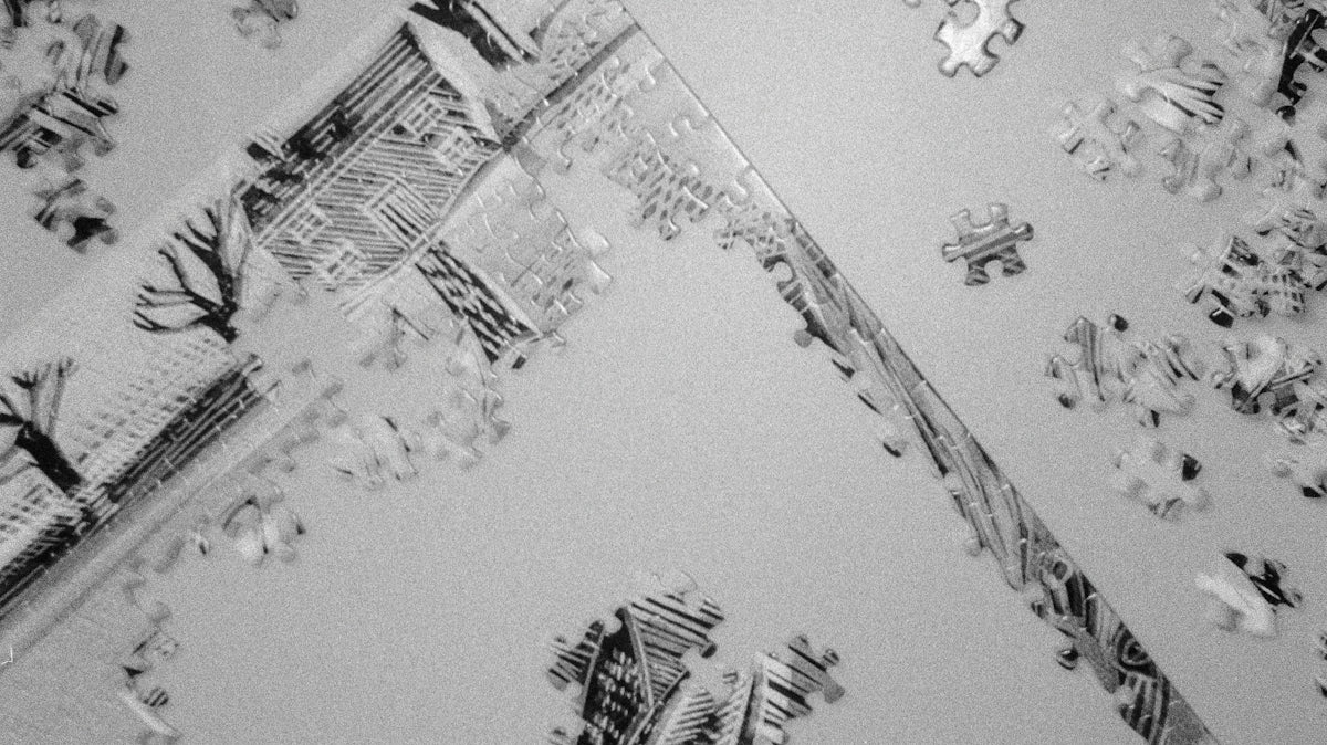 Scattered puzzle pieces and a partially assembled image