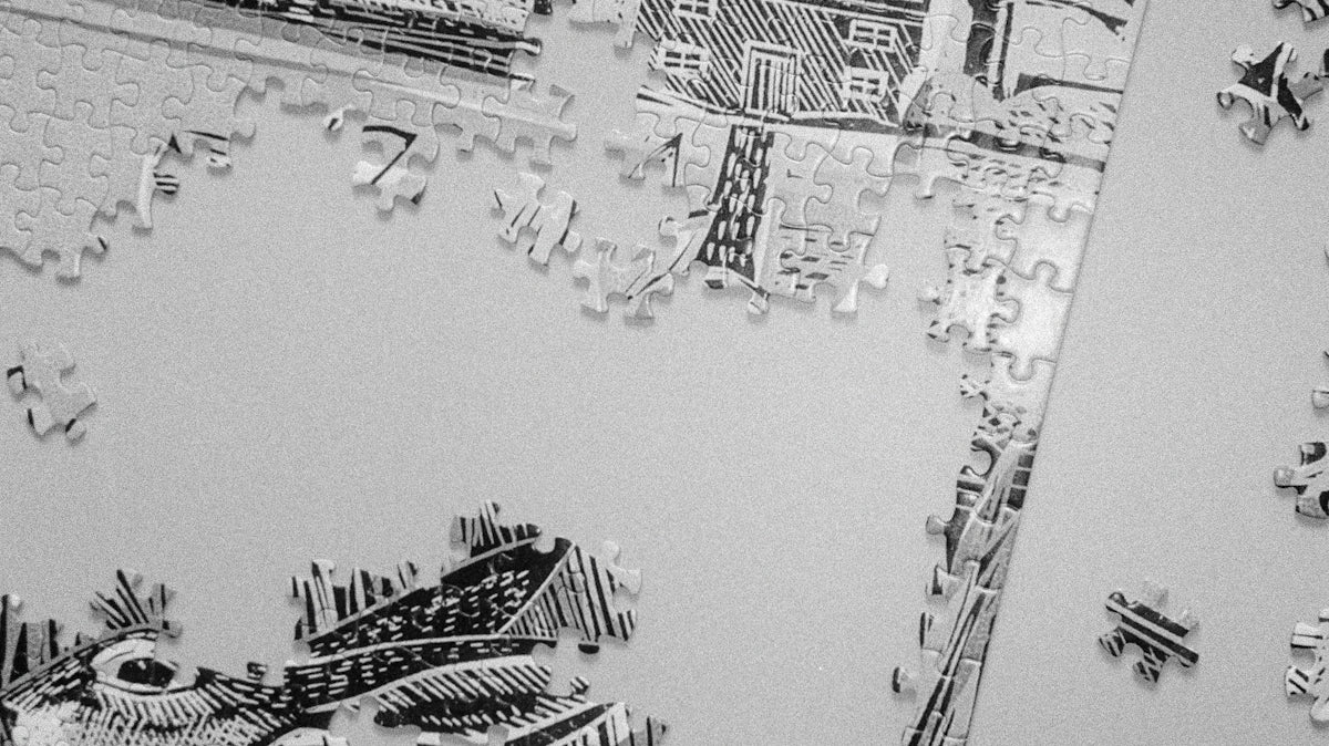 Scattered puzzle pieces and partially assembled puzzle