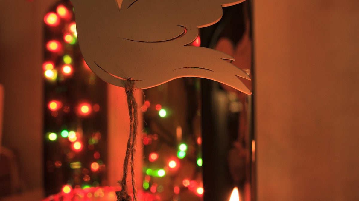 Candles and festive lights with a dove ornament