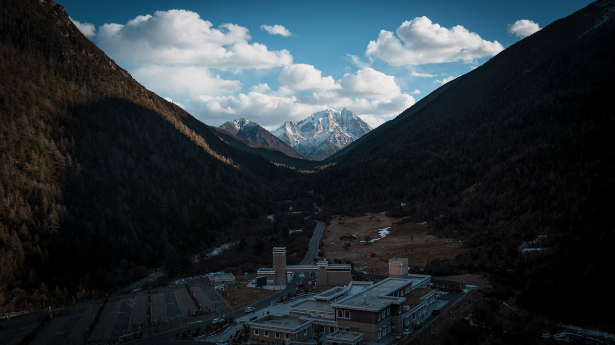 Snow-covered buildings nestled in a dark mountain valley.