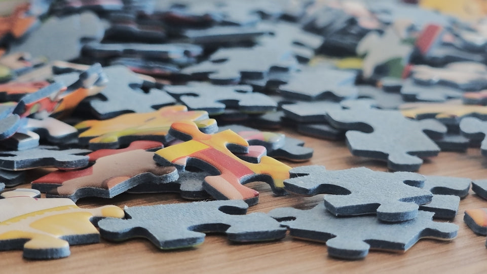 Scattered puzzle pieces on a wooden surface.
