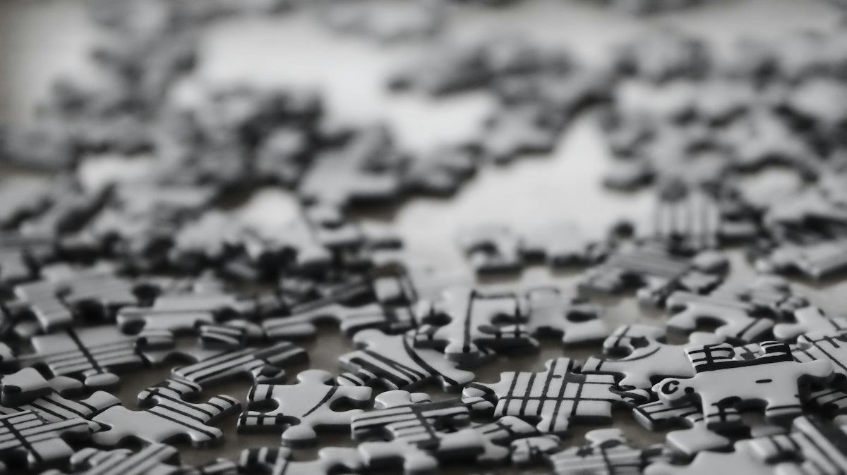 Scattered black and white puzzle pieces on a surface