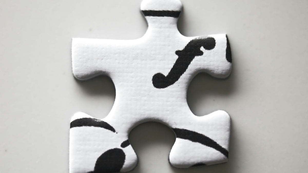 A white puzzle piece with black musical forte symbol