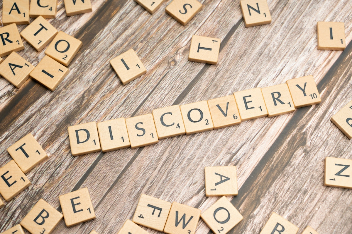 scrabble tiles spelling discovery on a wooden surface