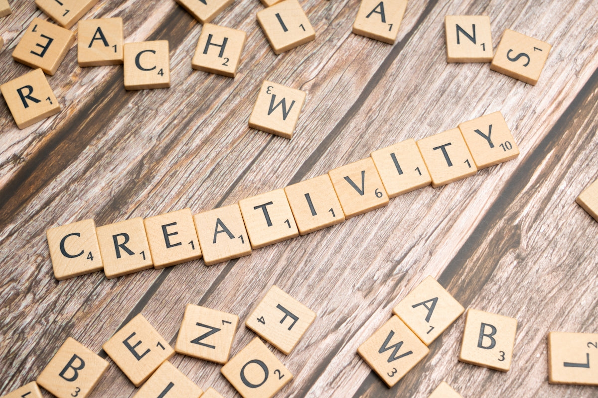 scrabble tiles spelling creativity on a wooden surface