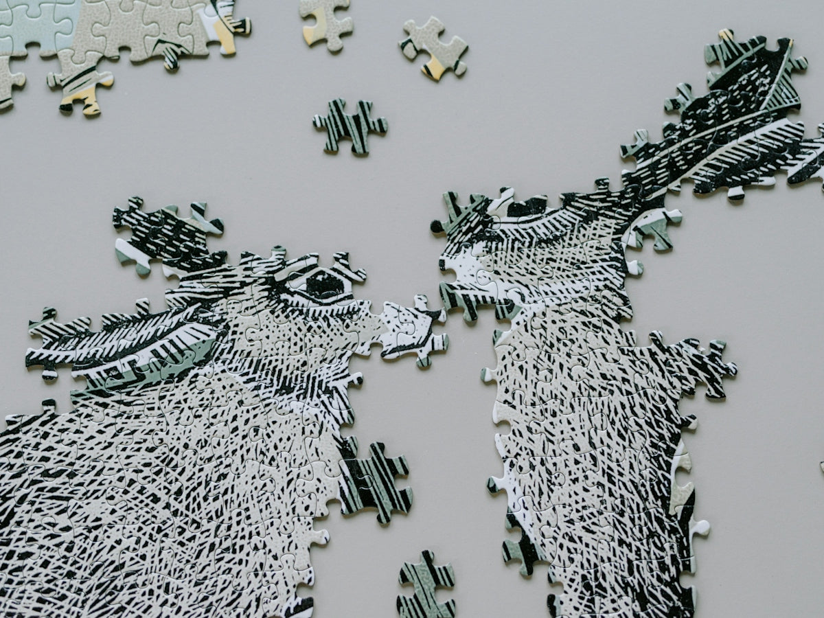 Two unfinished donkey puzzle pieces face each other