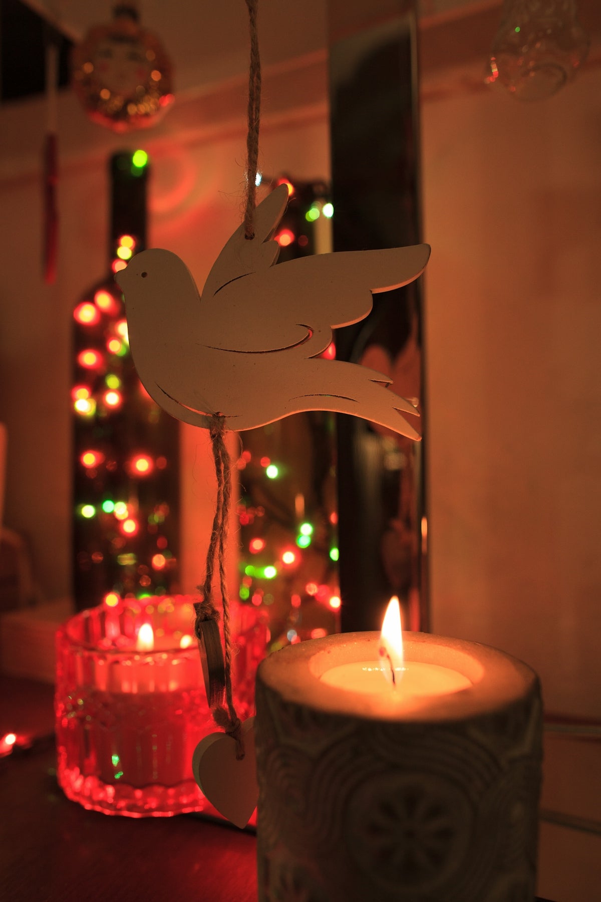 Candles and festive lights with a dove ornament
