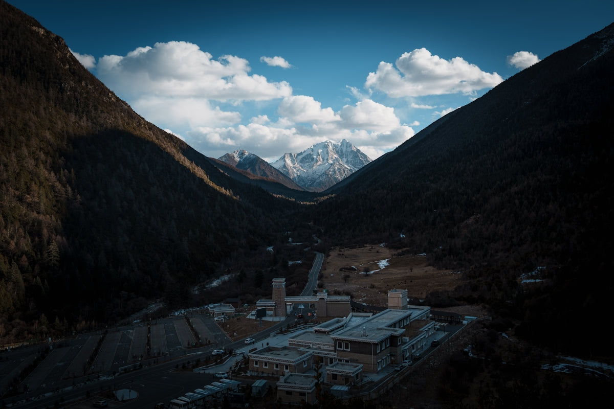 Snow-covered buildings nestled in a dark mountain valley.