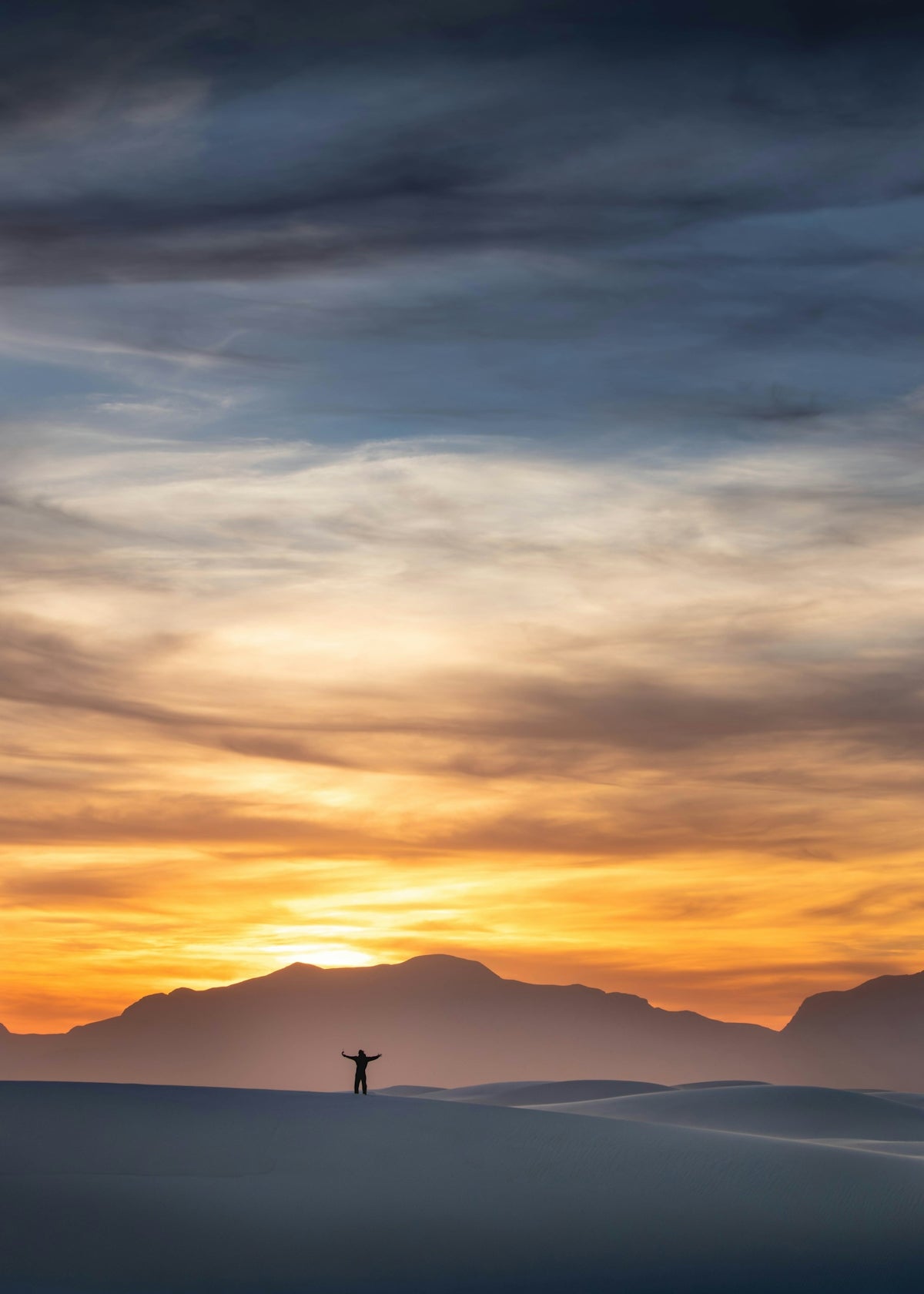 Silhouette of a person with arms outstretched at sunset