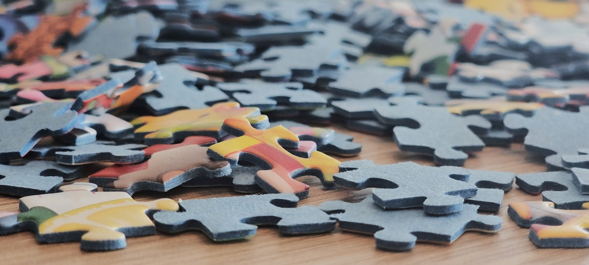 Scattered puzzle pieces on a wooden surface.