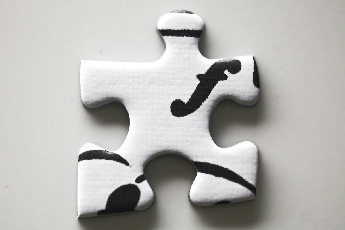 A white puzzle piece with black musical forte symbol